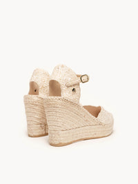 Beige wedge sandals with espadrille sole on a white background