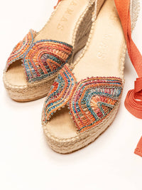 Colorful embroidered espadrilles on a white background