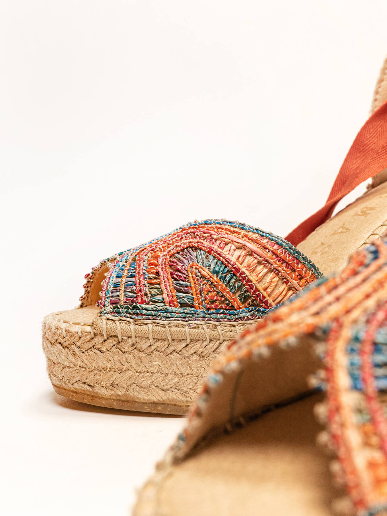 Colorful woven sandals with a textured sole on a white background