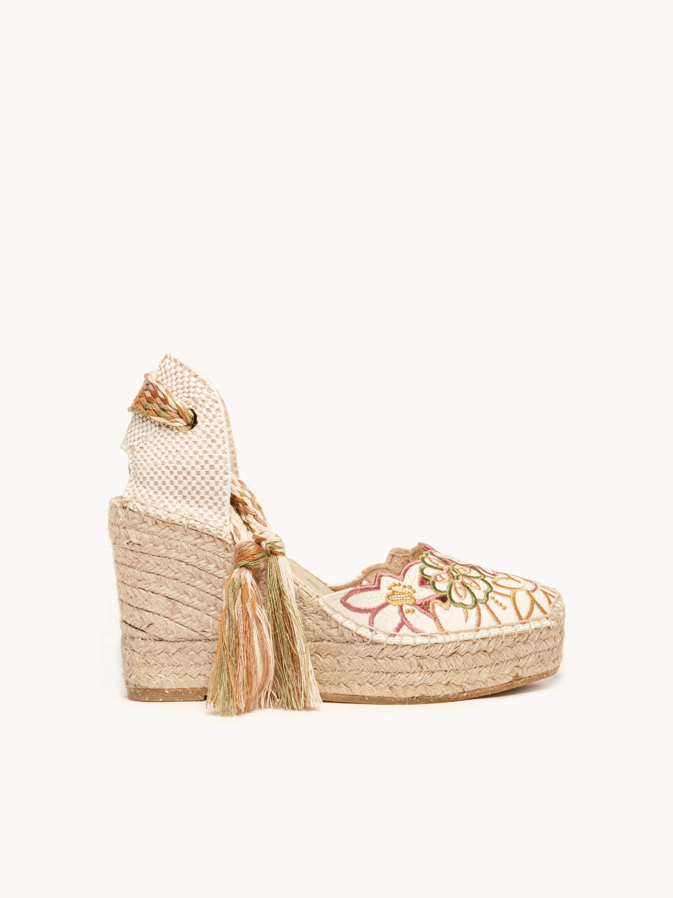 Woven wedge sandal with tassel on a white background