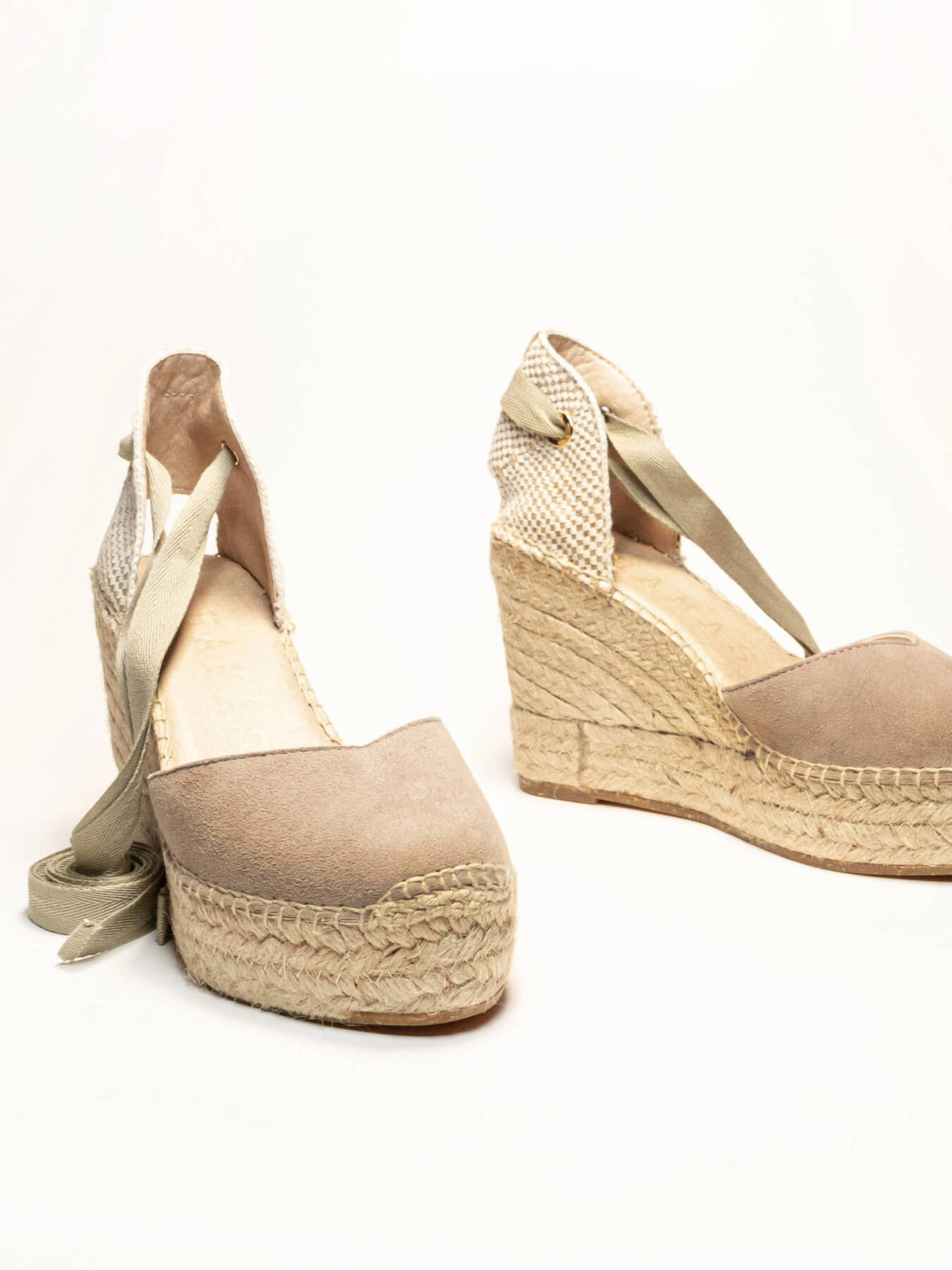 Beige wedge sandals with espadrille sole on a white background