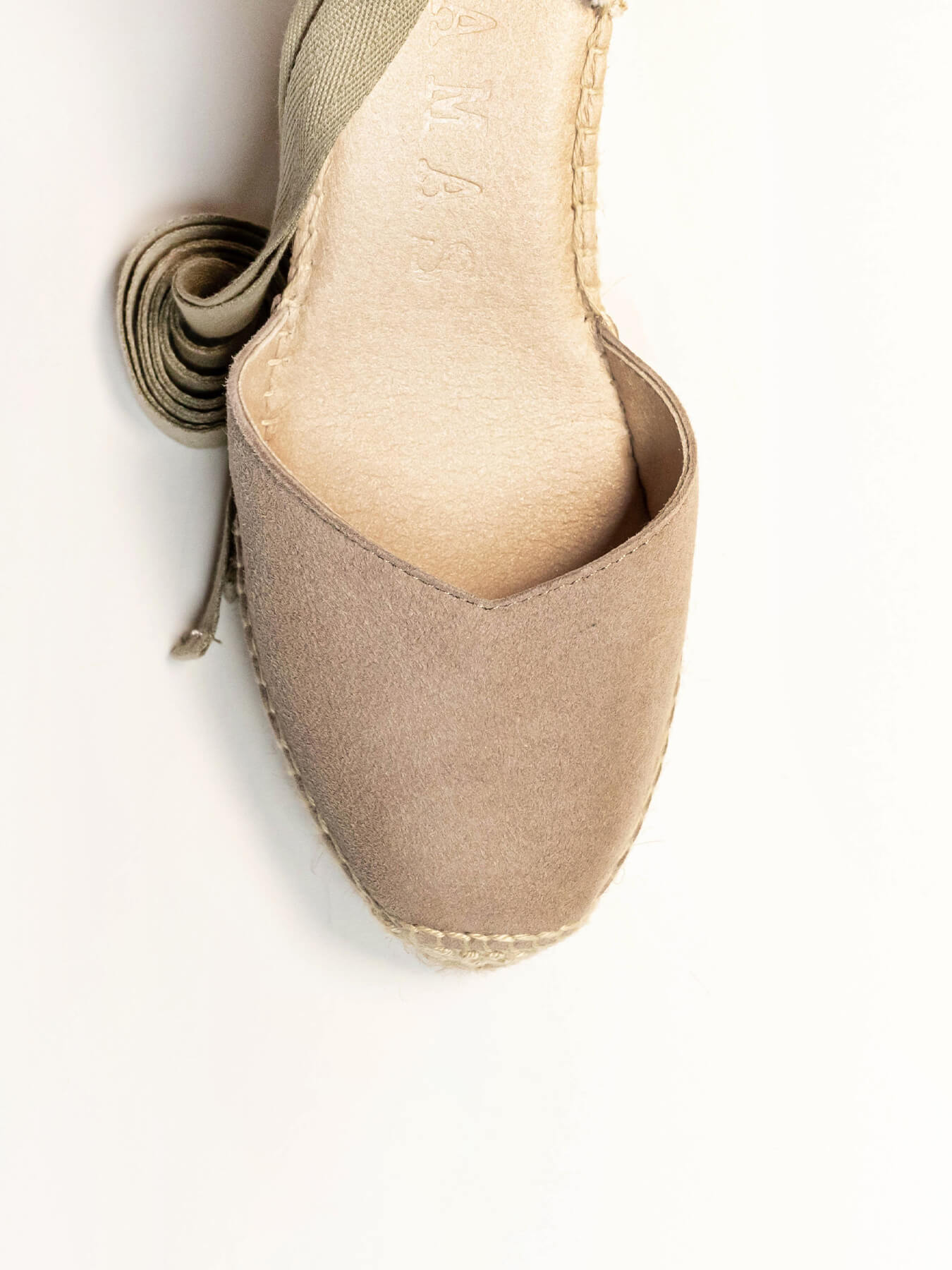 Close-up of a beige espadrille shoe on a white background