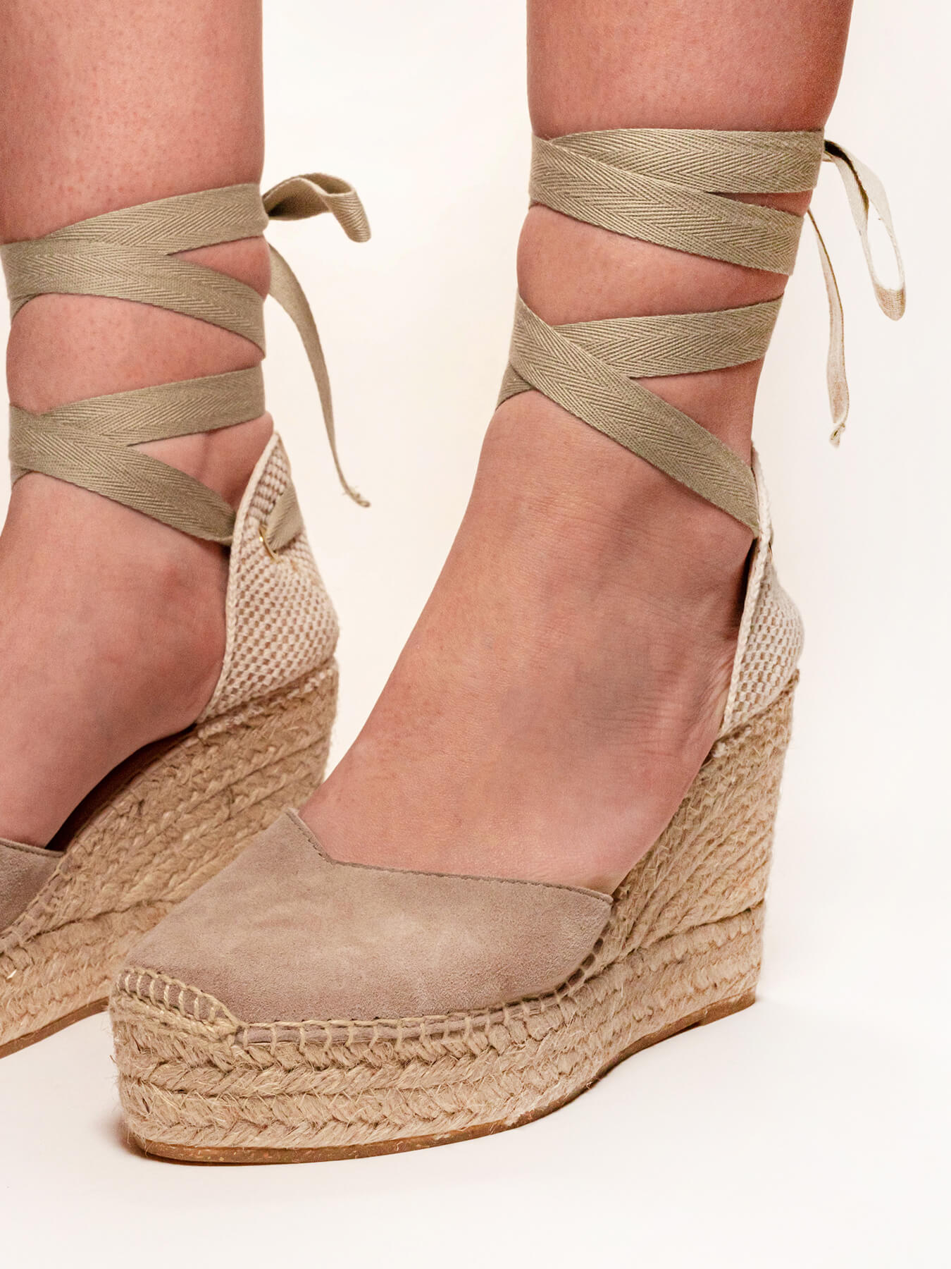 Beige wedge sandals with espadrille sole on a light background