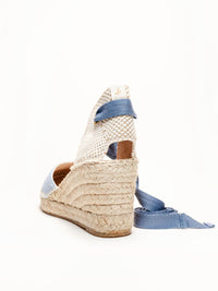 Woven wedge sandal with blue strap on a white background