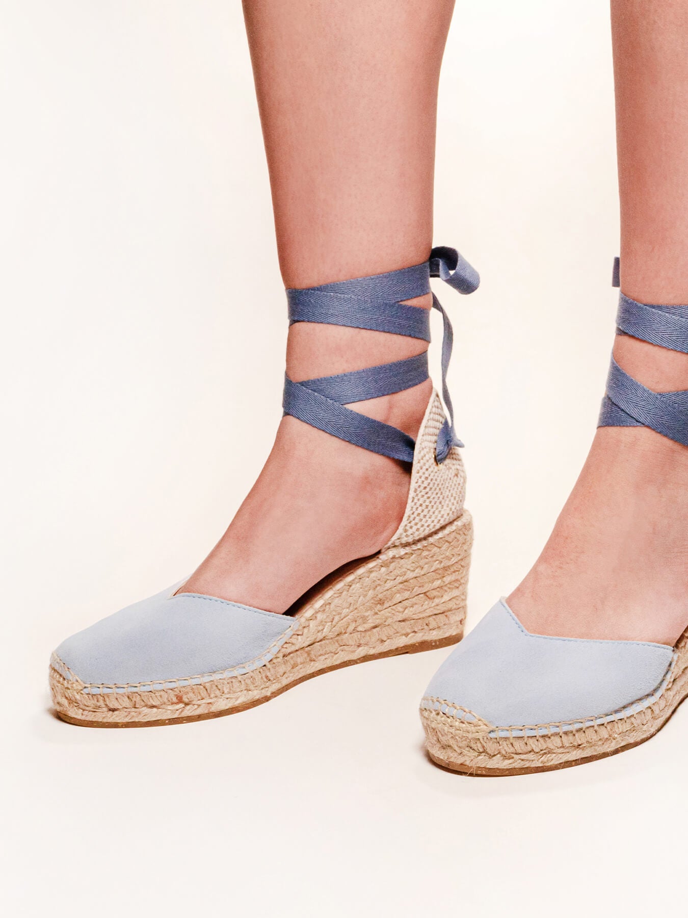 Blue wedge sandals with ankle straps on a white background