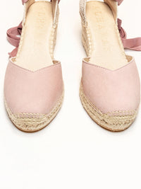 Pink espadrille sandals with jute sole on a white background