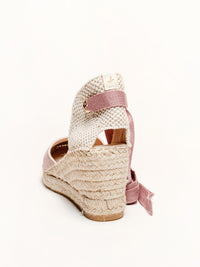 Woven wedge sandal with pink ribbon on a white background