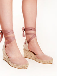 Pink wedge sandals with espadrille sole on a white background
